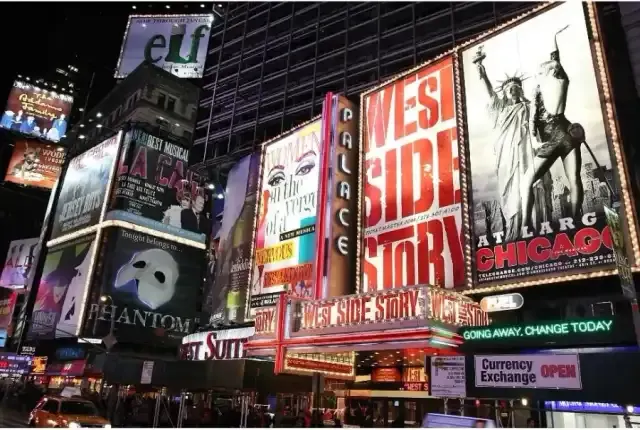 Broadway theater marquees including West Side Story and Chicago glowing at night