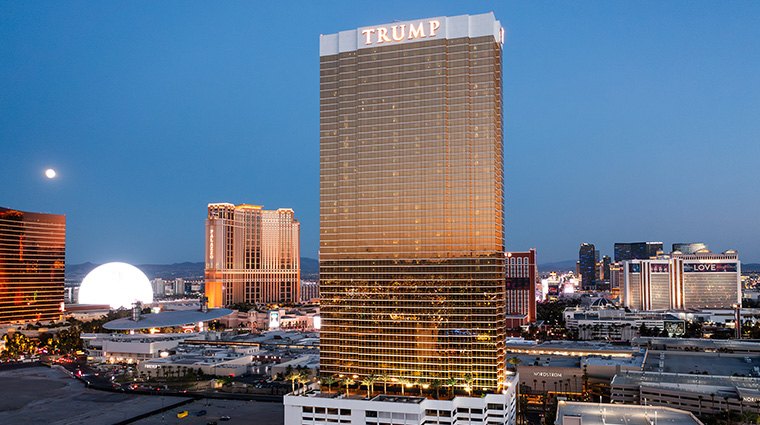 Trump Hotel Las Vegas golden tower towering over the Strip at dusk with the glowing Sphere nearby